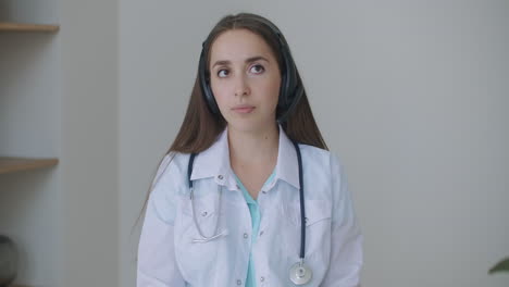 Looking-at-the-camera-listening-woman-doctor-looks-at-the-camera-and-listens-to-the-patient.-A-video-conference-listener.-Portrait-of-a-doctor